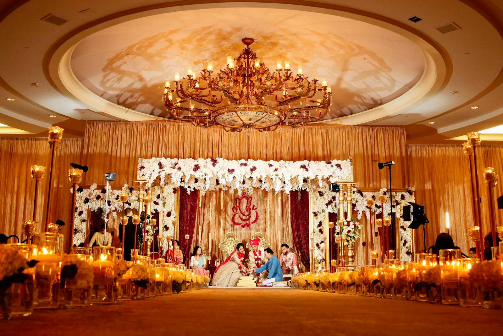 Couple performing a ritual under a floral mandap